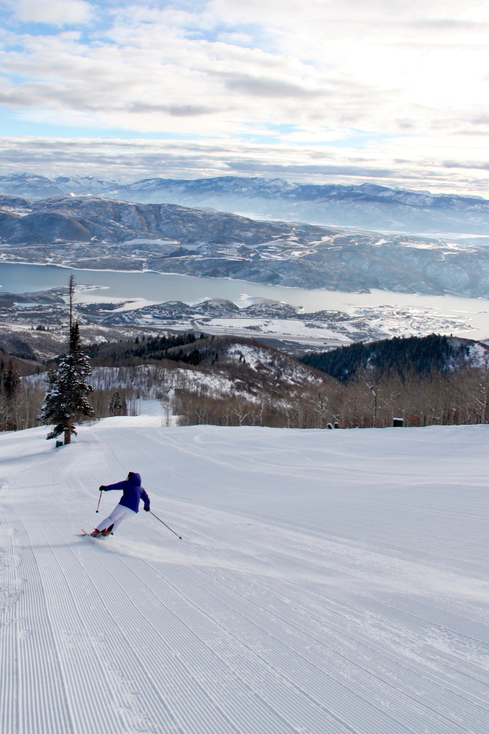 Skier on a Deer Valley groomed run, Jordanelle Reservoir below